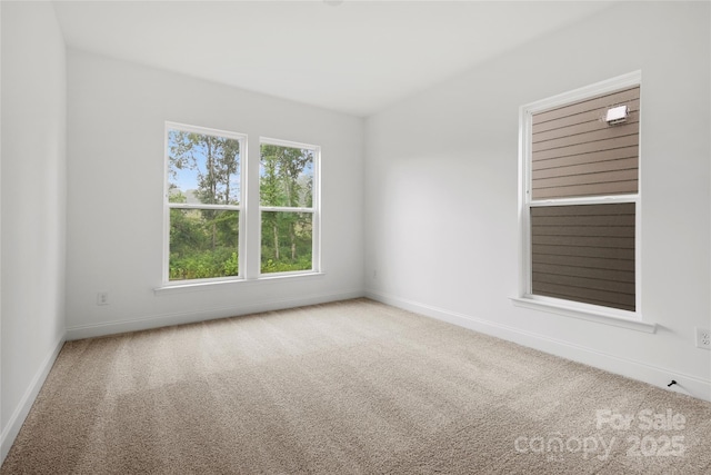 carpeted spare room featuring baseboards