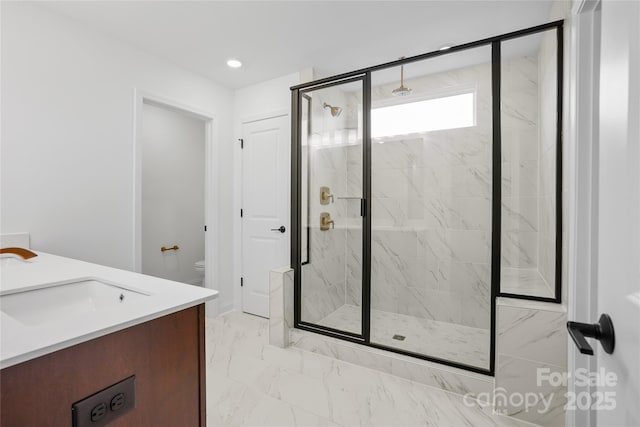 full bath featuring toilet, marble finish floor, a marble finish shower, and vanity