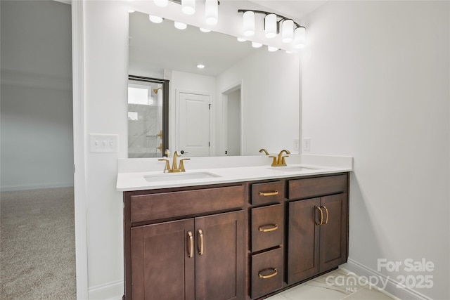 full bathroom featuring double vanity, baseboards, an enclosed shower, and a sink