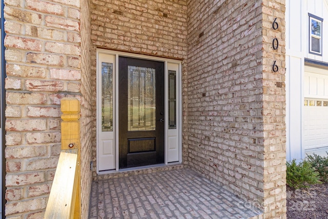 view of exterior entry featuring brick siding