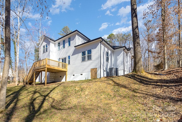 back of property with a deck, a yard, crawl space, and stairs