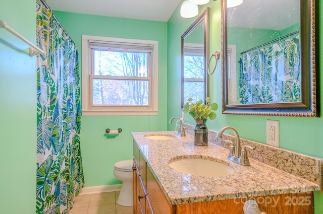 full bathroom featuring double vanity, toilet, a sink, and tile patterned floors