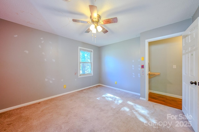 spare room featuring ceiling fan, carpet flooring, and baseboards