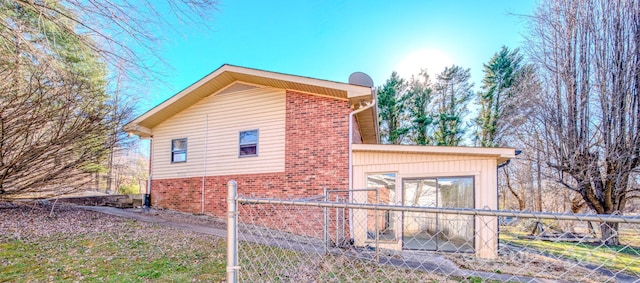 view of home's exterior with brick siding and fence