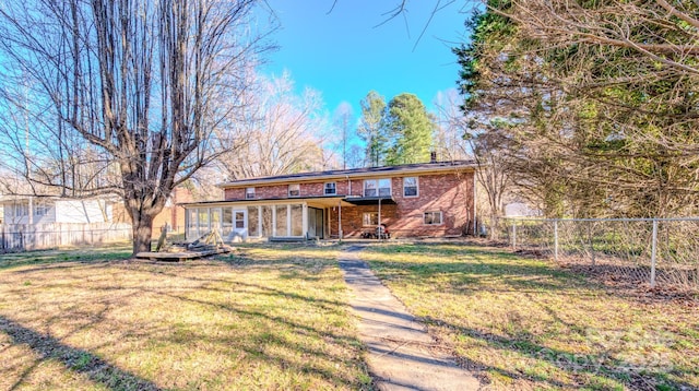 view of front facade featuring a front lawn, a fenced backyard, and brick siding