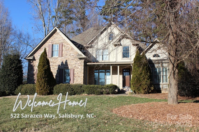 traditional home featuring stone siding and a front yard