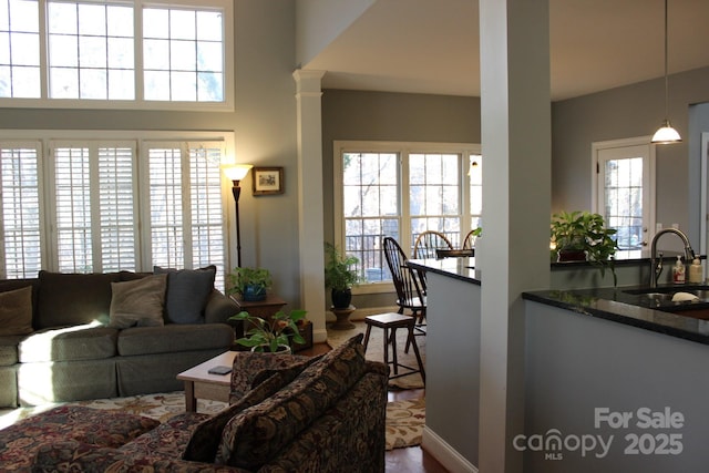 living area with ornate columns and a high ceiling