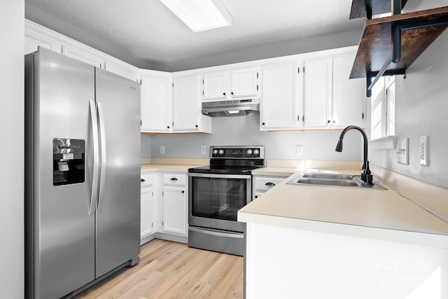 kitchen featuring white cabinets, appliances with stainless steel finishes, light wood-type flooring, under cabinet range hood, and a sink