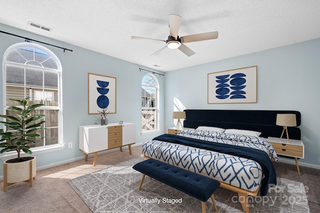 bedroom featuring carpet, visible vents, ceiling fan, a textured ceiling, and baseboards