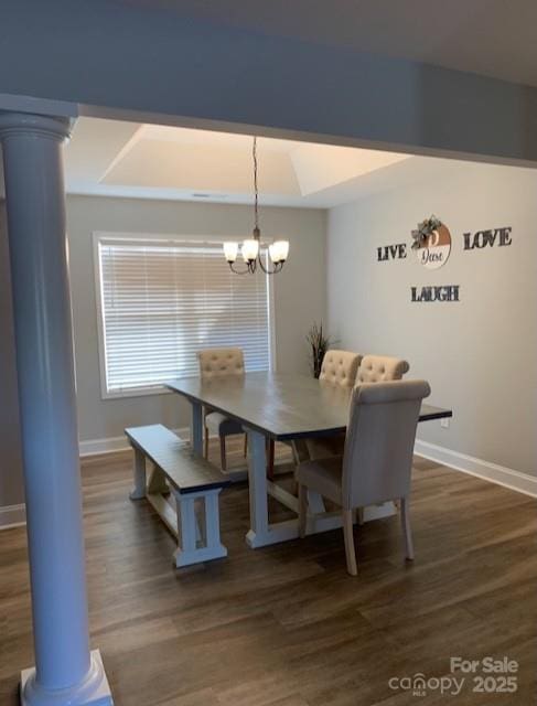 dining room with dark wood-style floors, a chandelier, baseboards, and ornate columns