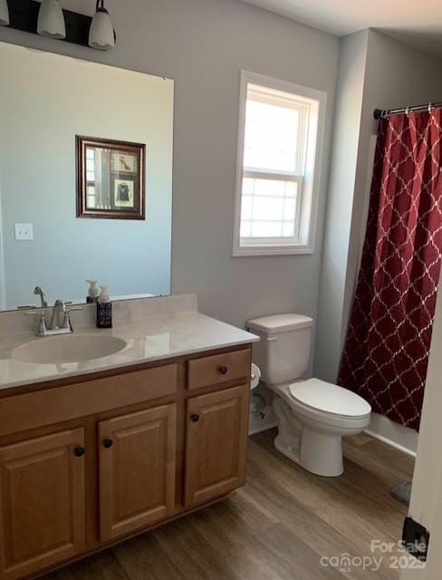 bathroom with vanity, a shower with shower curtain, wood finished floors, and toilet