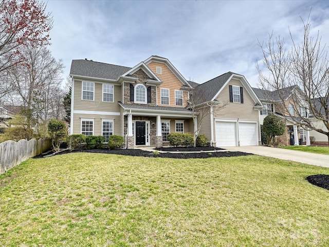 view of front of property with driveway, stone siding, fence, a front yard, and an attached garage