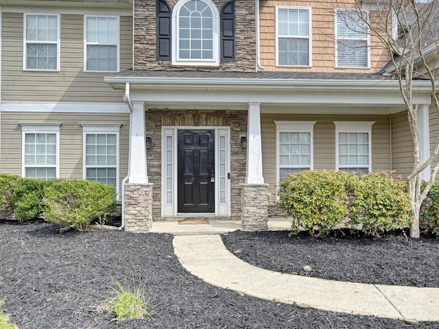 property entrance featuring stone siding and covered porch