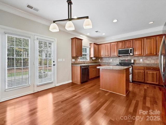 kitchen featuring visible vents, stainless steel appliances, dark wood-type flooring, and decorative backsplash