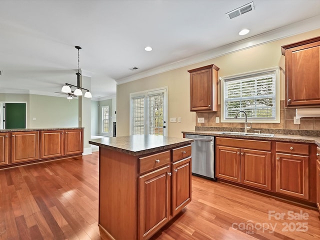 kitchen featuring dark countertops, visible vents, dishwasher, wood finished floors, and a sink