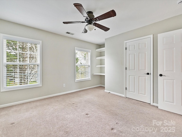 unfurnished bedroom with visible vents, a ceiling fan, baseboards, and carpet floors