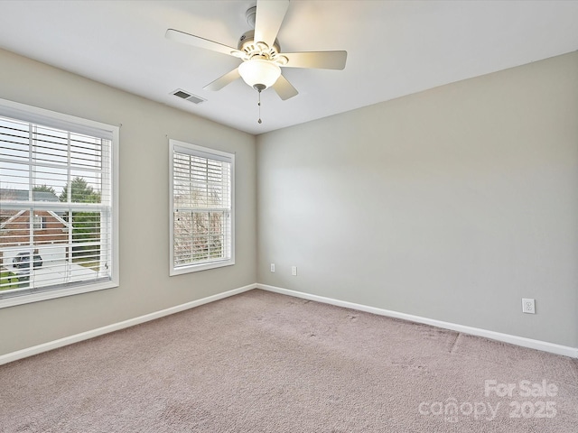 unfurnished room with visible vents, carpet flooring, a ceiling fan, and baseboards