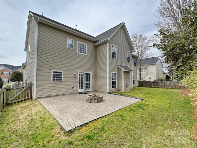 rear view of house featuring a yard, an outdoor fire pit, a fenced backyard, and a patio area