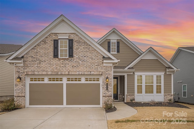 craftsman-style home with a garage, concrete driveway, and brick siding