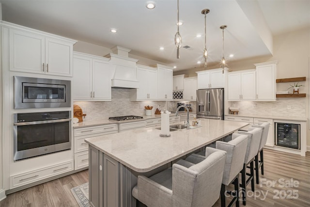 kitchen featuring appliances with stainless steel finishes, a sink, and white cabinetry