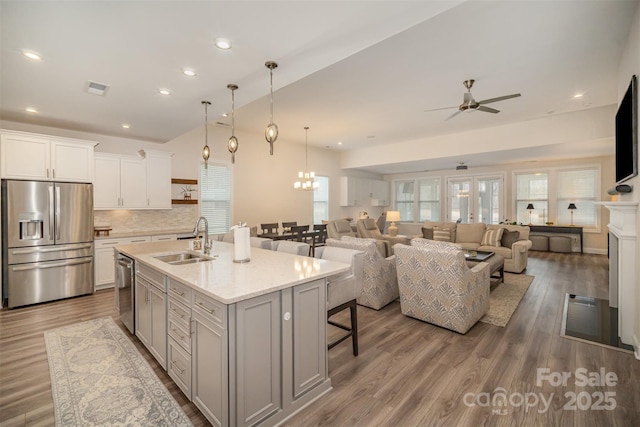 kitchen with visible vents, a breakfast bar area, appliances with stainless steel finishes, wood finished floors, and a sink