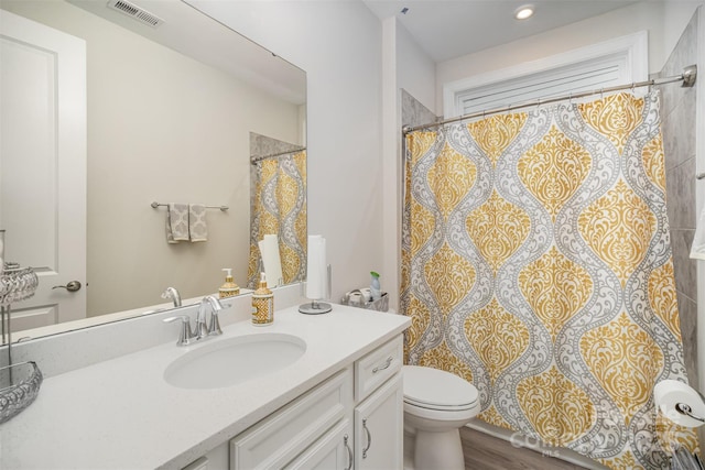 full bathroom featuring toilet, visible vents, a shower with shower curtain, and vanity