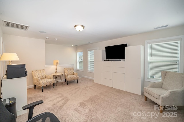 living area with visible vents and carpet flooring