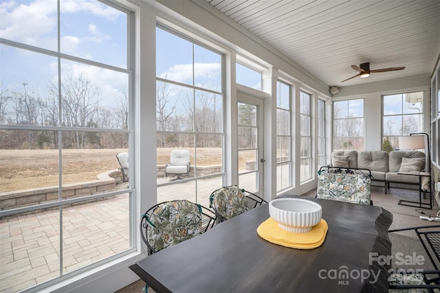 sunroom featuring a ceiling fan and a wealth of natural light