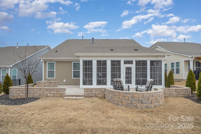 rear view of house featuring a sunroom, a patio, and a fire pit