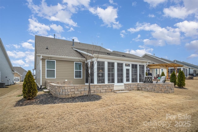 rear view of property featuring a shingled roof, a sunroom, central AC, and a patio