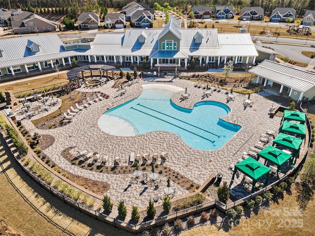 pool with a residential view, a patio, and an outdoor fire pit