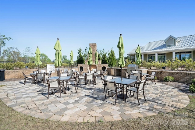 view of patio featuring outdoor dining space and a lit fireplace