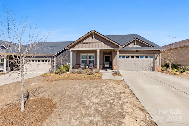 craftsman-style home with concrete driveway, an attached garage, covered porch, board and batten siding, and brick siding