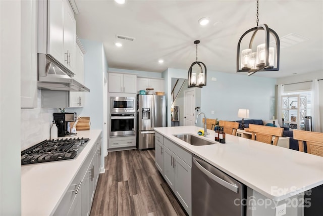 kitchen featuring under cabinet range hood, stainless steel appliances, a sink, visible vents, and light countertops