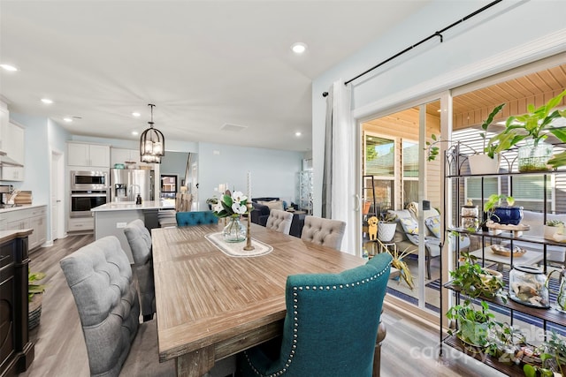 dining space featuring a chandelier, wood finished floors, and recessed lighting