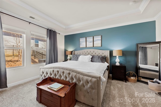 bedroom with baseboards, crown molding, visible vents, and a tray ceiling