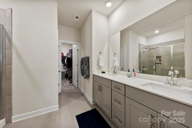 bathroom featuring a stall shower, a spacious closet, visible vents, and a sink