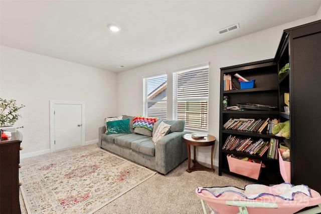 sitting room with carpet flooring, visible vents, and baseboards