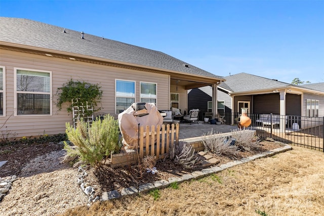 back of house with roof with shingles, a patio, and fence