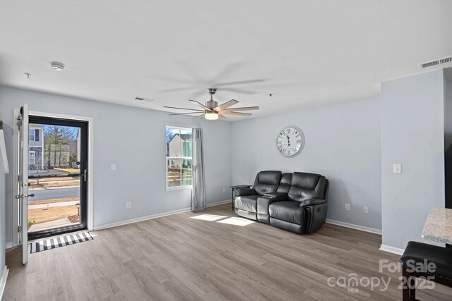 sitting room with wood finished floors, visible vents, and a healthy amount of sunlight