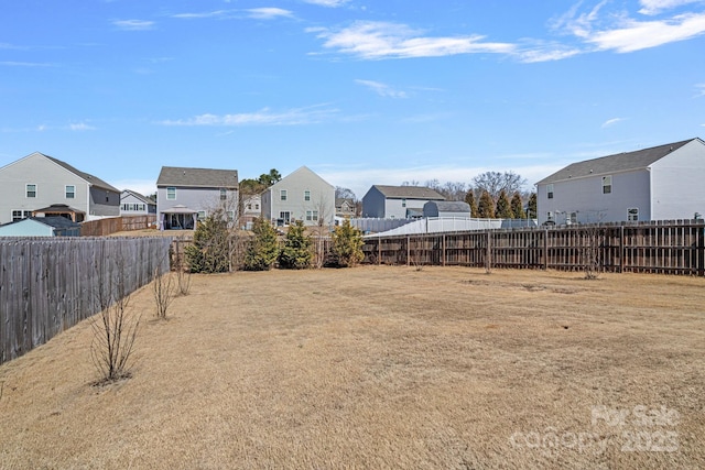 view of yard featuring a residential view and a fenced backyard