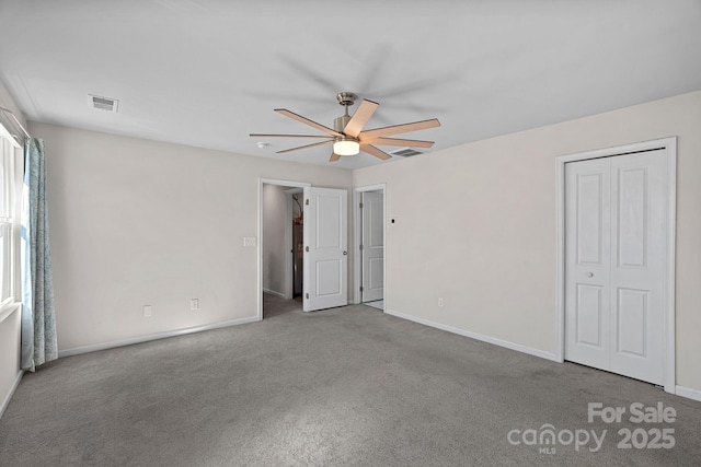 unfurnished bedroom featuring baseboards, visible vents, ceiling fan, and carpet flooring