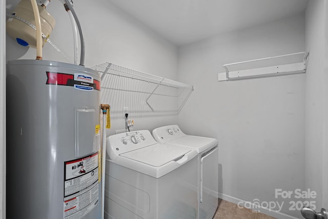 laundry area with laundry area, water heater, washer and clothes dryer, and tile patterned floors