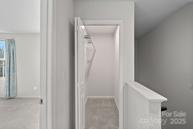 hallway featuring carpet floors and baseboards