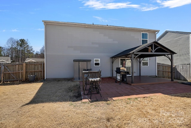 back of property featuring a yard, a patio, a gazebo, and fence