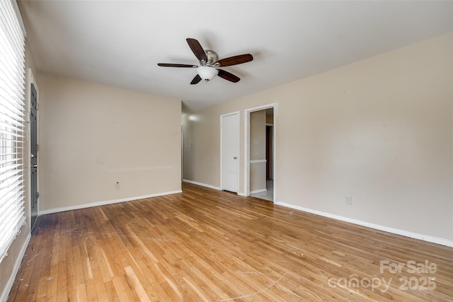 spare room with light wood finished floors, baseboards, and a ceiling fan