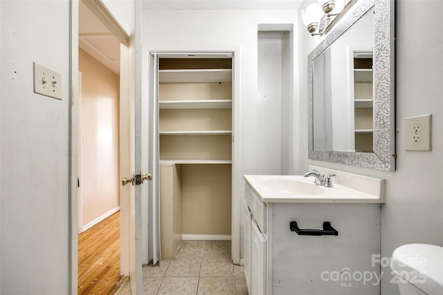 bathroom featuring baseboards, vanity, toilet, and tile patterned floors