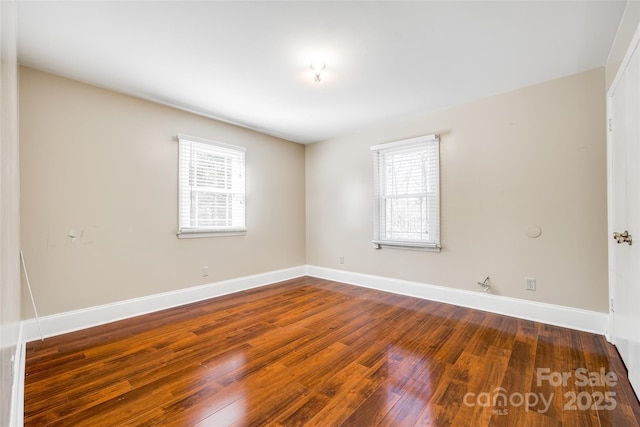 spare room with hardwood / wood-style flooring and baseboards