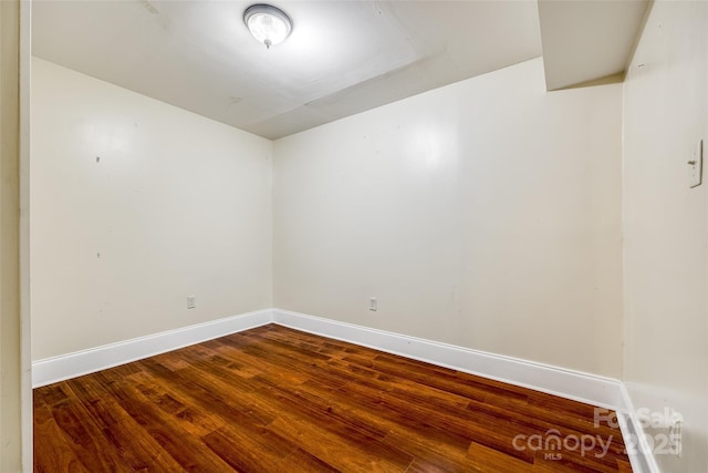 empty room featuring wood finished floors and baseboards