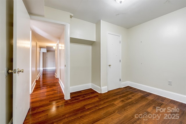 empty room with baseboards and wood finished floors